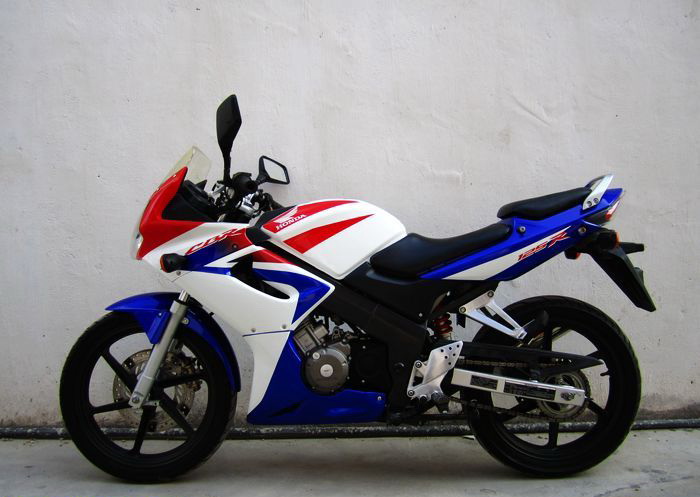 本田CBR125RR摩托车 引擎形式四衝程水冷DOHC四汽閥單汽缸 缸徑 x 衝程63.5 mm x 47.2mm 壓縮比 11.0:1 總排氣量125 cc 最高馬力21ps 最大扭力-kg-m/rpm車架形式鋁合金框式車架 傳動系統 六前速鏈傳動濕式多片離合器 燃油供應 化油器 前傾角( R)25度 拖曳距(T)88mm 前懸掛系統套管前叉 後懸掛系統單筒油壓避震 輪胎(前)80/90 - 17 44P 輪胎(後)100/80 - 17 52P 前掣動系統276mm單剎車碟 配雙活塞卡鉗 後掣動系統2